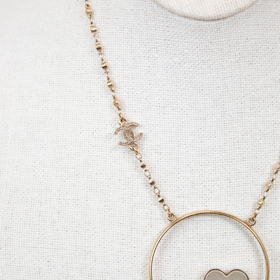 Necklace with a floral pendant and pearl on a light gray background