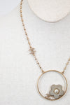 Necklace with a floral pendant and pearl on a light gray background