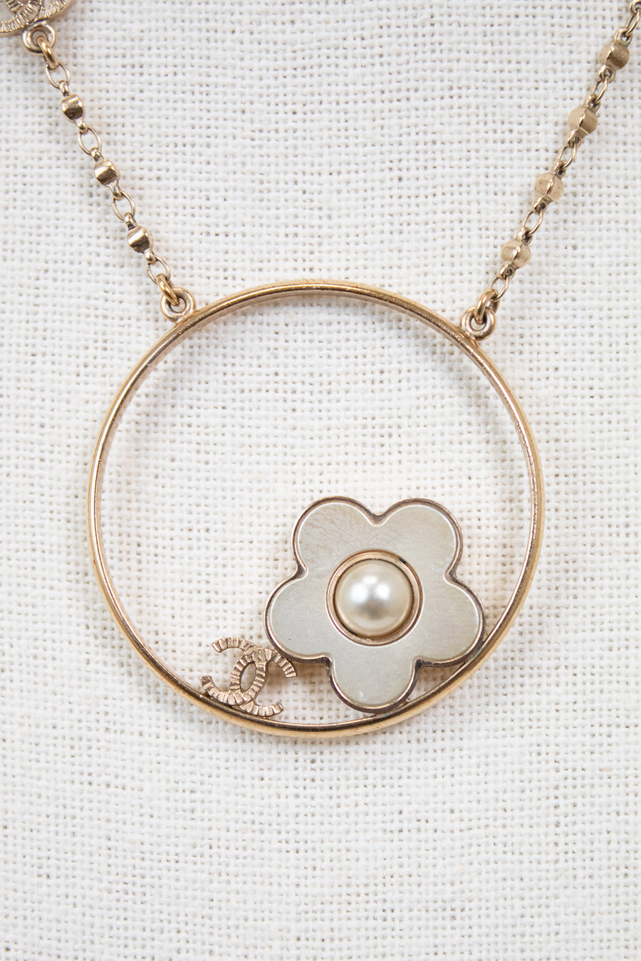 Necklace with a floral pendant and pearl on a white background