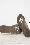 Pair of black shoes with gray soles and white logo on a light background