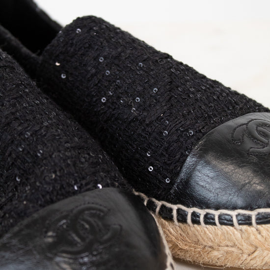 Black espadrilles with sequin details on a light background