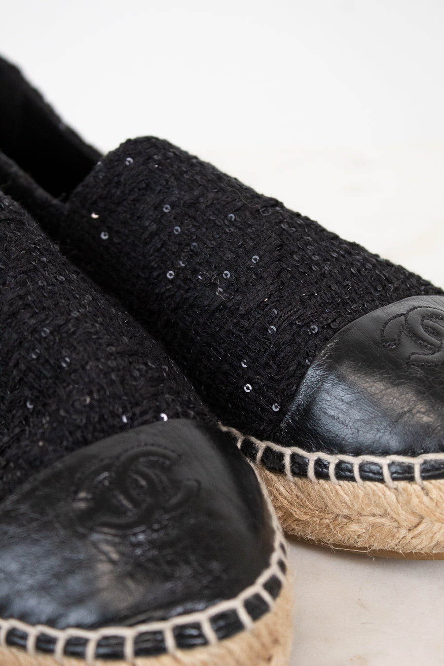 Black espadrilles with sequin details on a light background