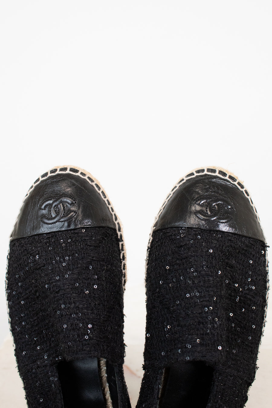 Black Chanel shoes with sequin details on a white background
