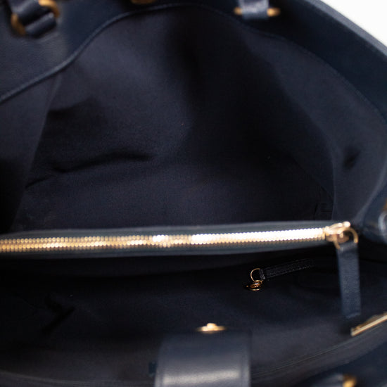 Close-up of a navy blue handbag with gold zipper and hardware.