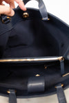 Close-up of a navy blue handbag with gold zipper and hardware.
