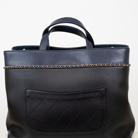 Black leather tote bag with chain detail on a white background