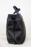 Black leather handbag with gold chain detail on a white background