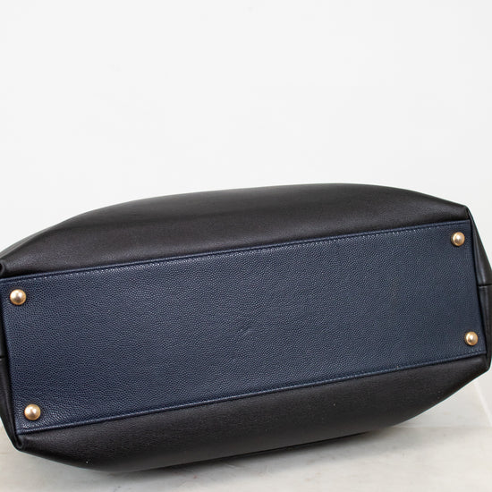 Black leather handbag with gold studs on a white background