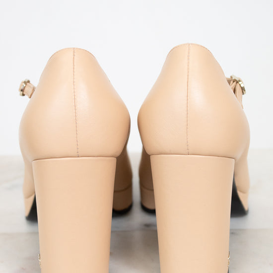 Pair of beige high-heeled shoes on a light gray background