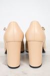 Pair of beige high-heeled shoes on a light gray background