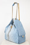 A light blue quilted Chanel shoulder bag with gold-tone hardware, shown on a white surface against a white background.