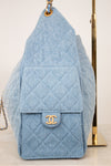 A light blue quilted denim shoulder bag with a gold-tone interlocking CC logo on the front flap, displayed against a light background.