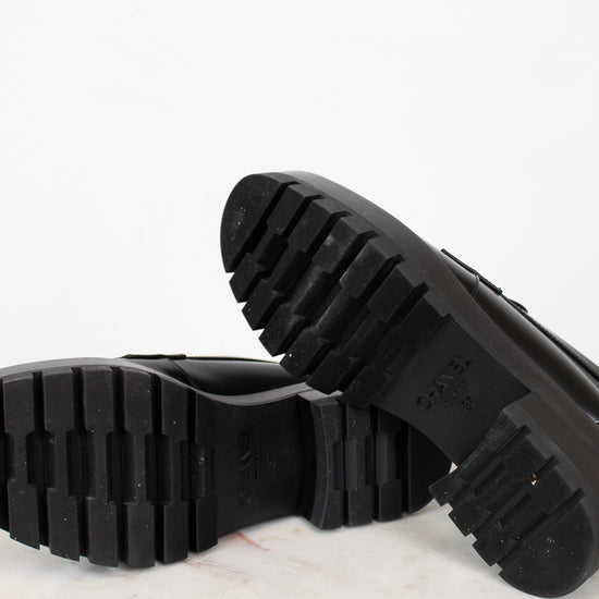 Close-up of black shoes soles on a marble surface