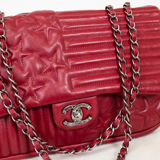 Red quilted handbag with a chain strap on a light background