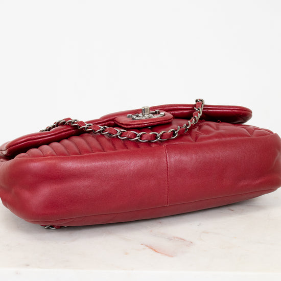 Red leather handbag with a chain detail on a light background