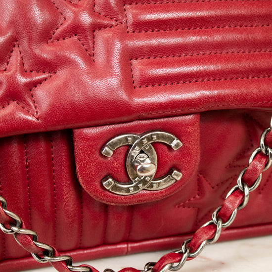 Red quilted handbag with Chanel logo and chain detail on a light background