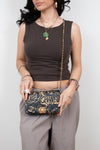 Woman holding a Chanel handbag against a plain background
