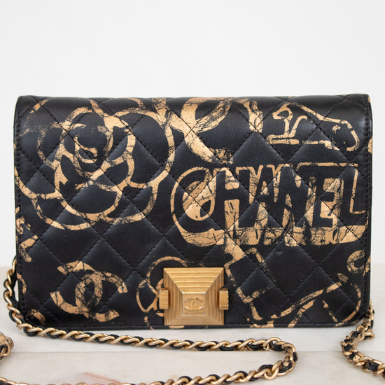 Chanel handbag with black and gold design on a white background