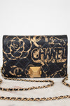 Chanel handbag with black and gold design on a white background