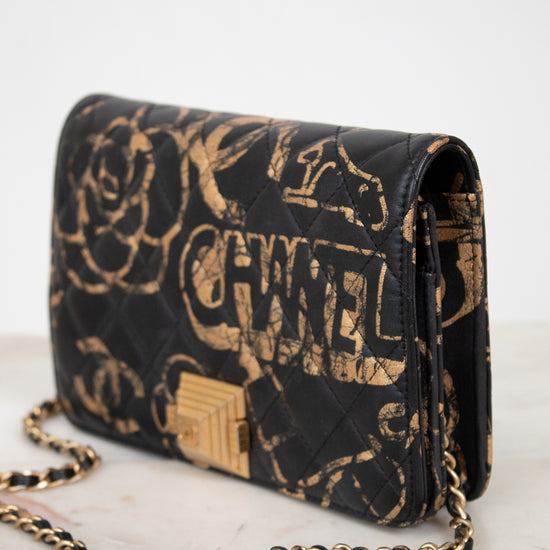 Black Chanel handbag with gold chain on a white background