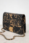 Black Chanel handbag with gold chain on a white background