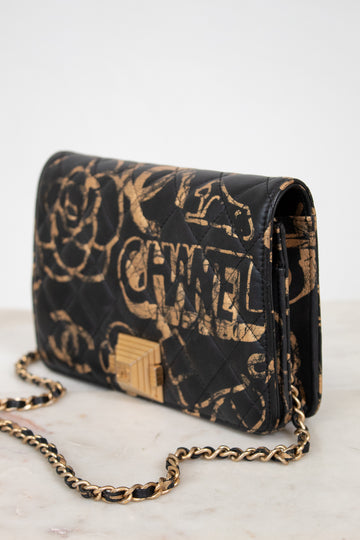 Black Chanel handbag with gold chain on a white background