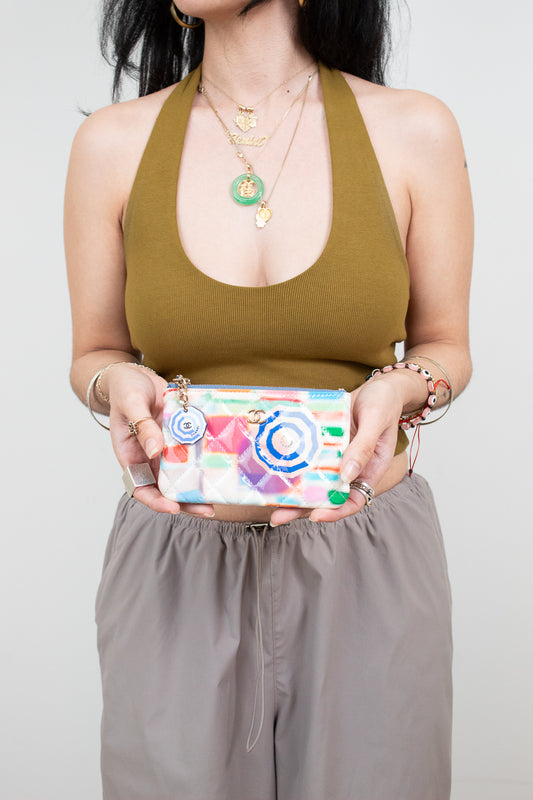 Person holding a colorful pouch with a plain background