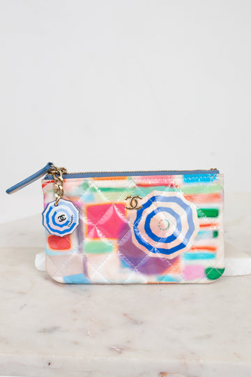Colorful pouch with disc swirl design and Chanel logo on a light gray background
