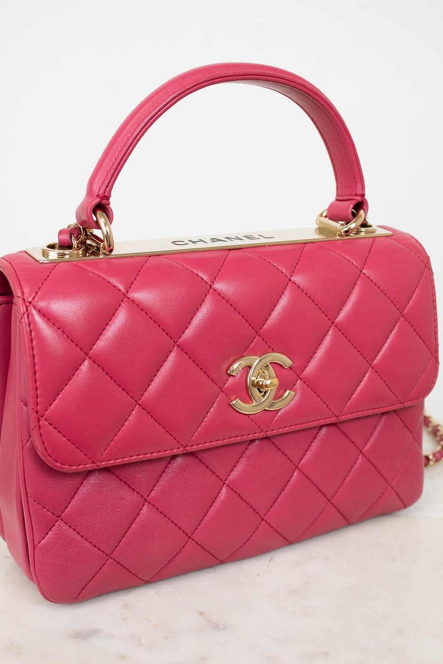 Pink quilted handbag with Chanel logo on a light background