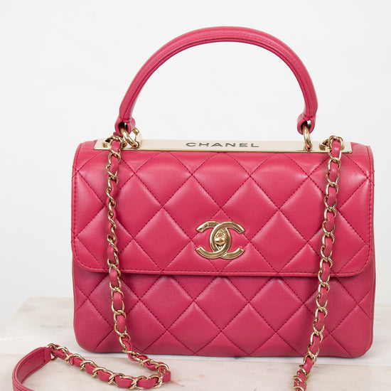 Pink Chanel handbag with gold chain on a white background