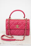 Pink Chanel handbag with gold chain on a white background