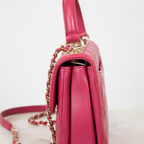Pink handbag with gold chain on a white background