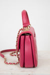 Pink handbag with gold chain on a white background