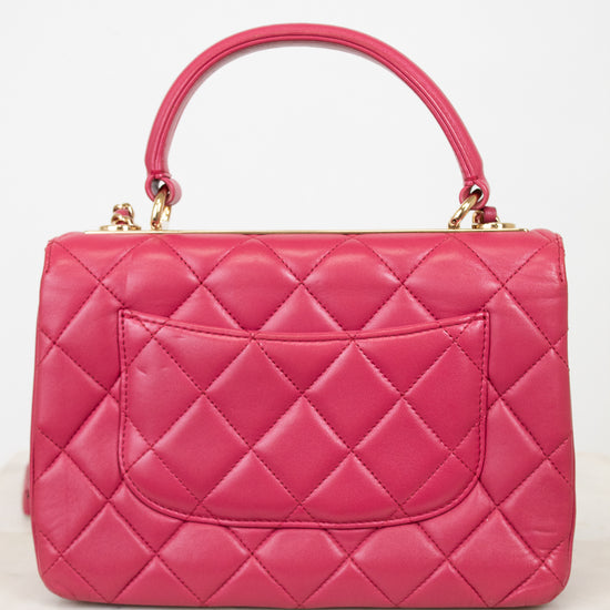 Pink quilted handbag on a white background