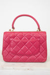 Pink quilted handbag on a white background