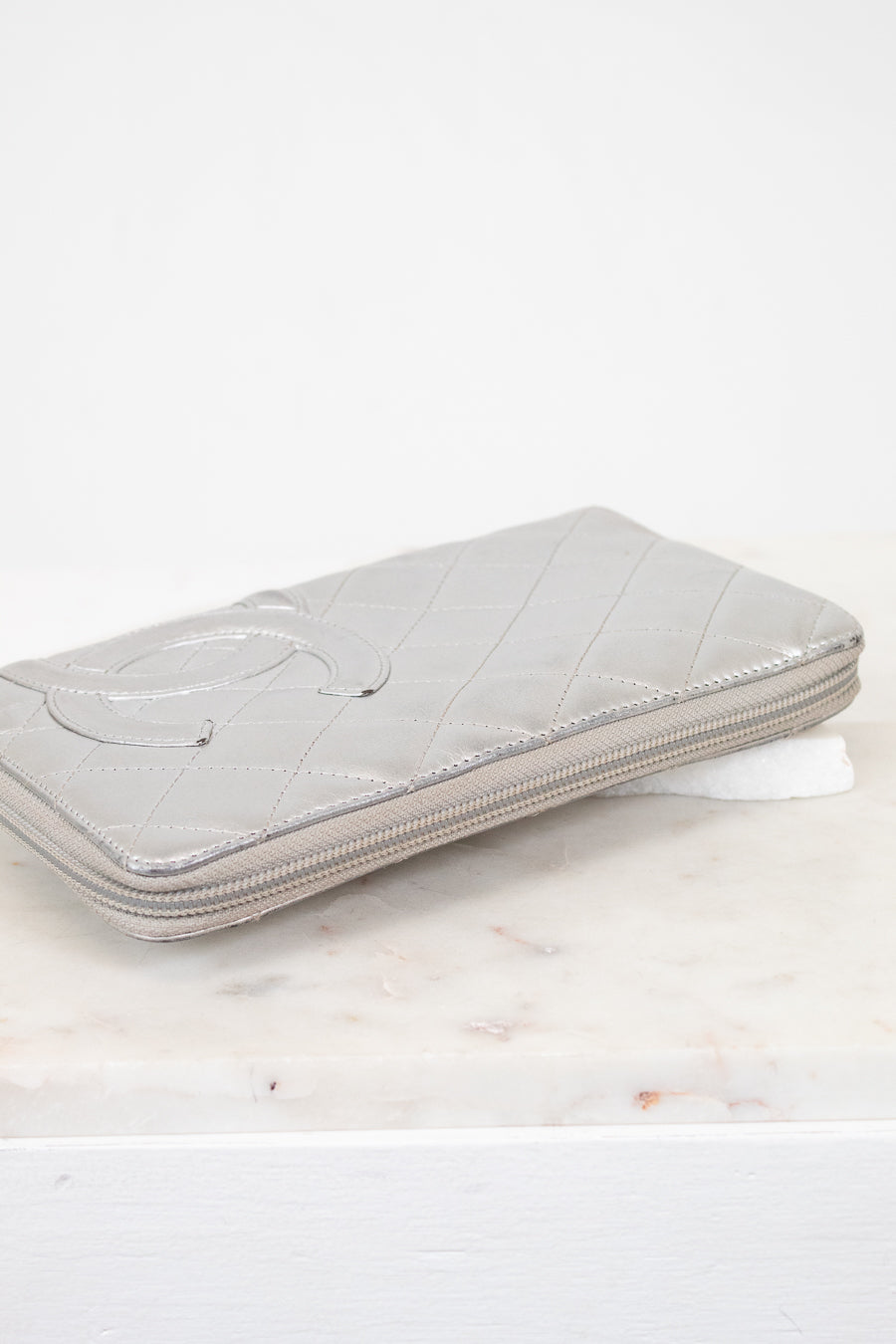 Silver quilted wallet on a marble surface