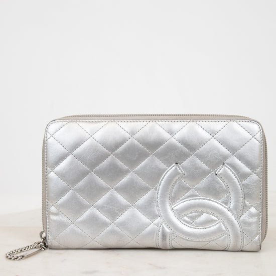 Silver quilted wallet with a brand logo on a white background