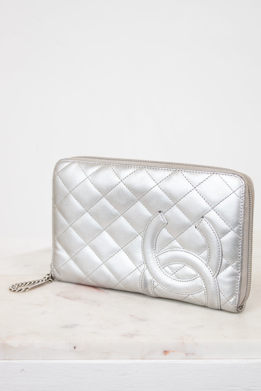 Silver quilted clutch on a white surface