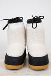 Pair of white fuzzy snow boots with black details on white background.
