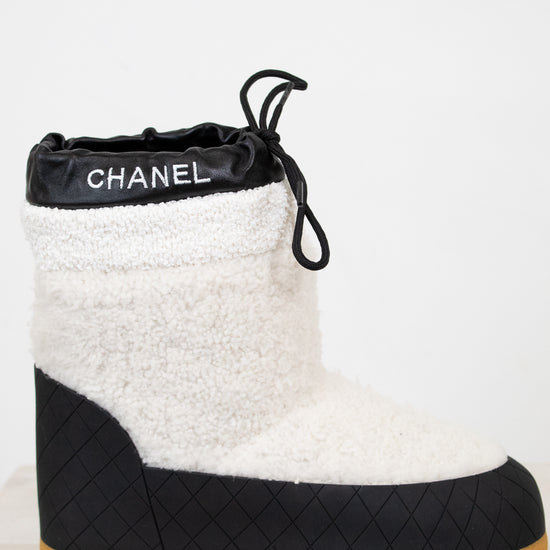 Chanel black and white quilted boot with tan sole on a light background
