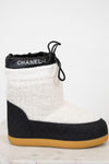Chanel black and white quilted boot with tan sole on a light background