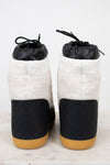 Pair of black and white shoes with quilted design on a light background