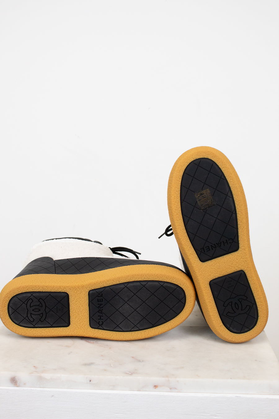 Pair of shoes with tan soles and black soles on a white background