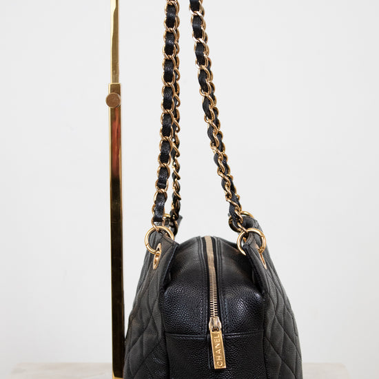 Black handbag with gold chain strap on a white background