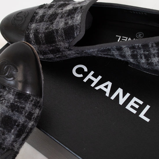 Black tweed Chanel shoes on a white background
