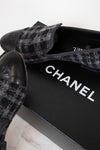 Black tweed Chanel shoes on a white background