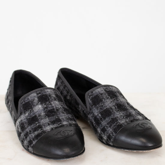 Pair of black and gray checkered loafers on a white background