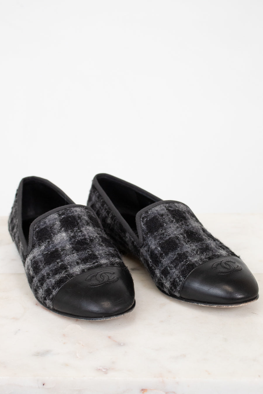 Pair of black and gray checkered loafers on a white background