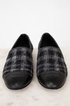 Pair of black and gray checkered tweed Chanel loafers on a white background