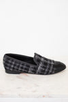 Black and gray checkered tweed loafer on a white marble surface